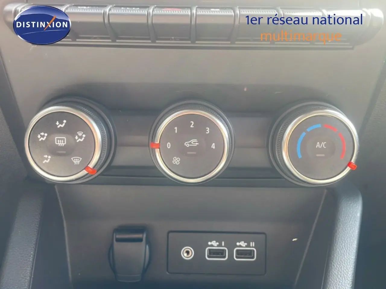 Détail du tableau de bord de la Renault Clio blanche 2025, montrant les commandes de climatisation et ports USB.