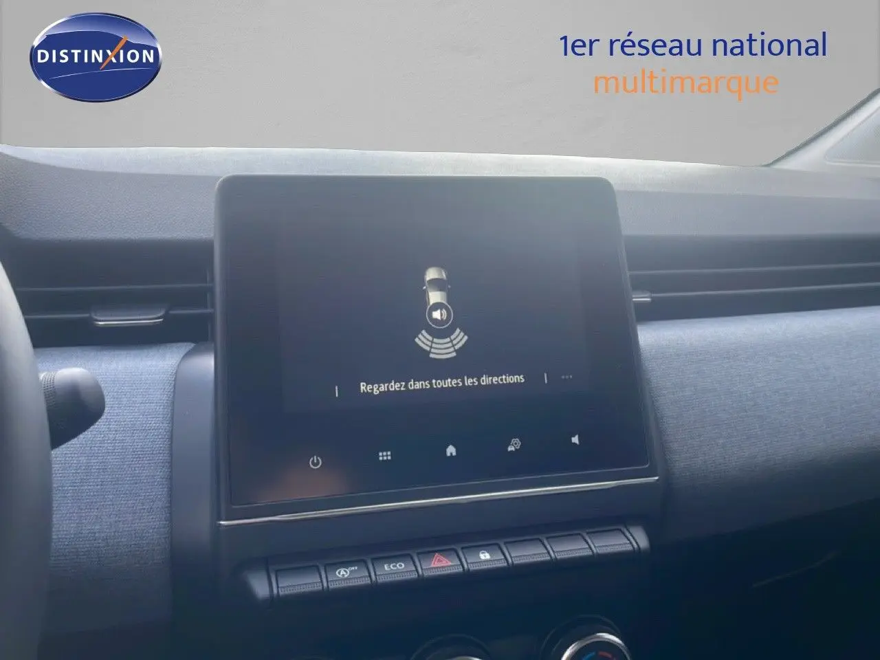 Écran tactile central du tableau de bord de la Renault Clio blanche 2025, avec affichage d'alerte de sécurité.