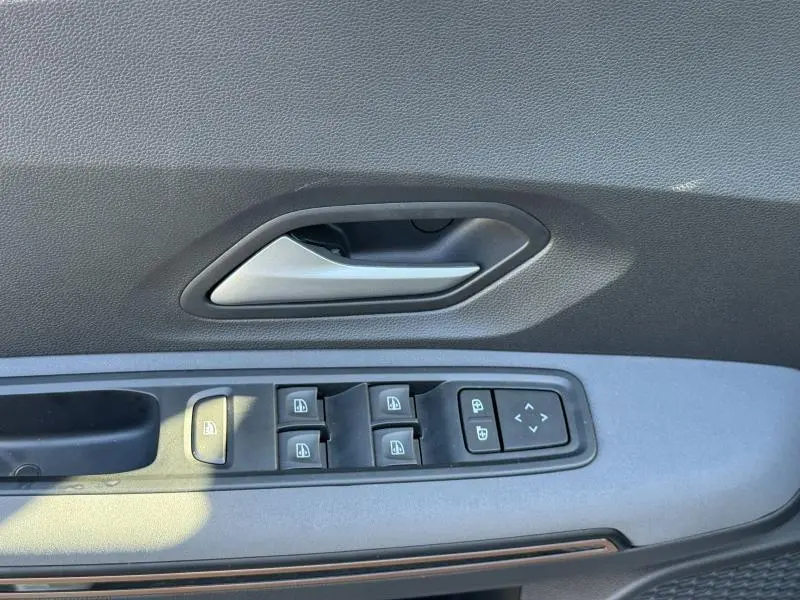 Poignée de porte intérieure côté gauche gris foncé avec commandes des vitres et rétroviseurs du Dacia Jogger 2024.