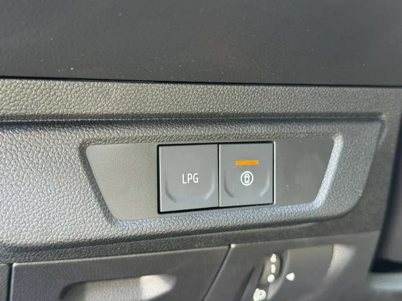 Gros plan sur les boutons de commande LPG et verrouillage intérieur sur tableau de bord noir du Dacia Jogger 2024.