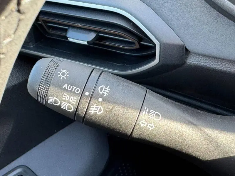 Gros plan sur la commande des phares et clignotants du Dacia Jogger 2024, intérieur noir avec détails gris.