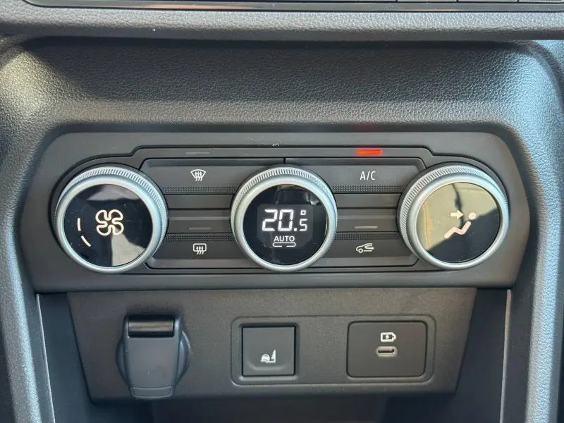 Vue rapprochée du tableau de bord du Dacia Jogger 2024, montrant les commandes de climatisation digitales et boutons fonctionnels.