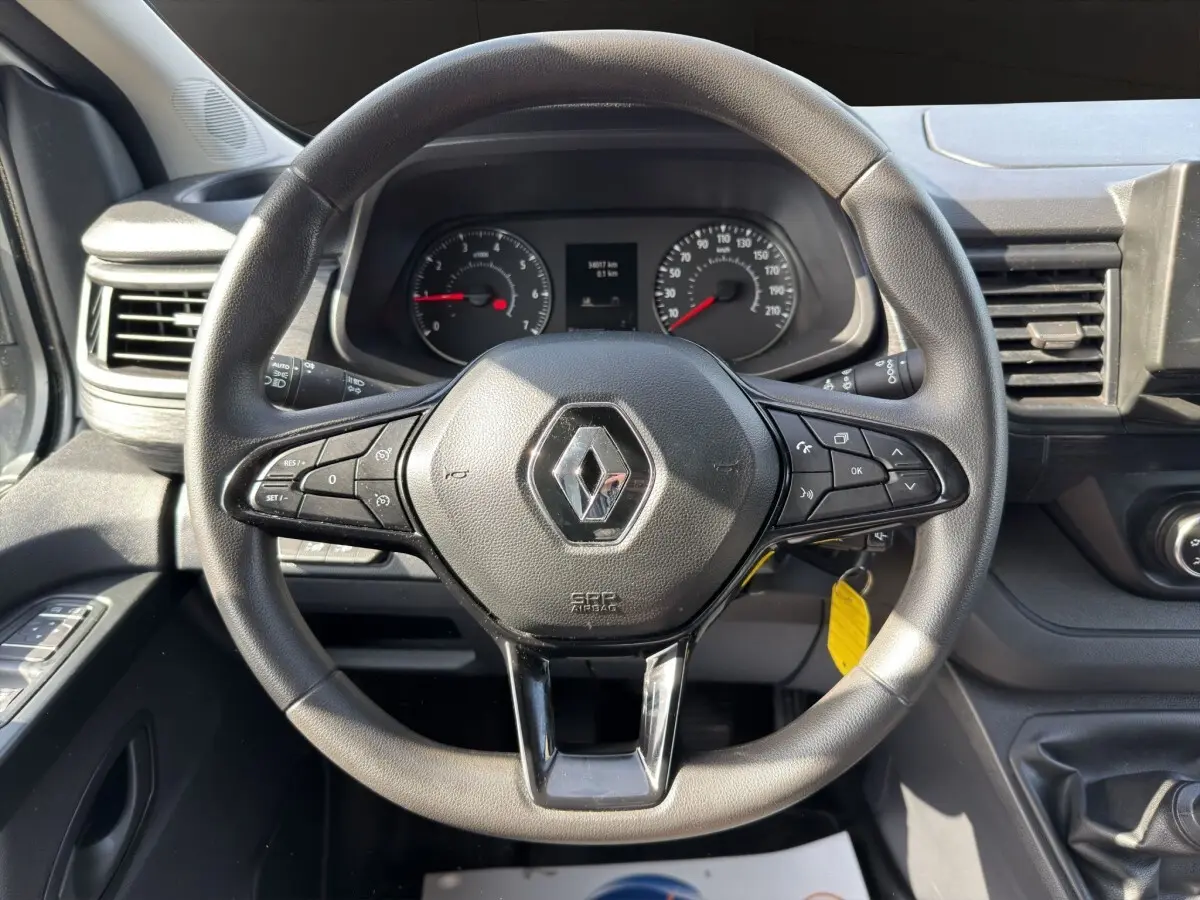 Vue intérieure centrée sur le volant multifonctions noir du Renault Trafic Fourgon avec tableau de bord et commandes visibles.