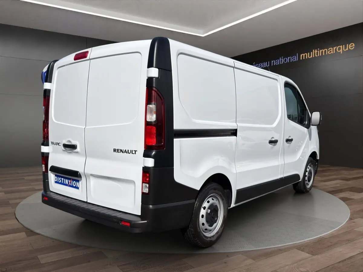 Vue 3/4 arrière droite d’un Renault Trafic Fourgon blanc avec feux arrière verticaux et pare-chocs noir.