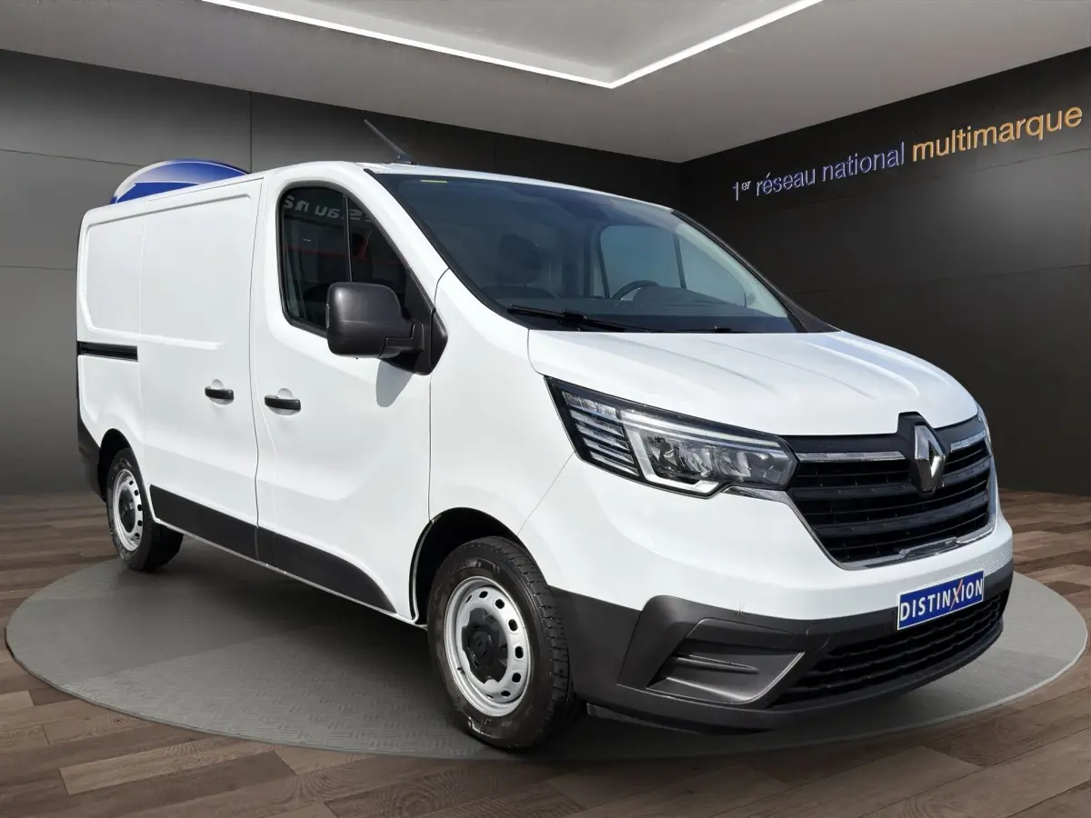 Renault Trafic Fourgon blanc en 3/4 avant droit, avec phares LED et calandre noire distinctive.