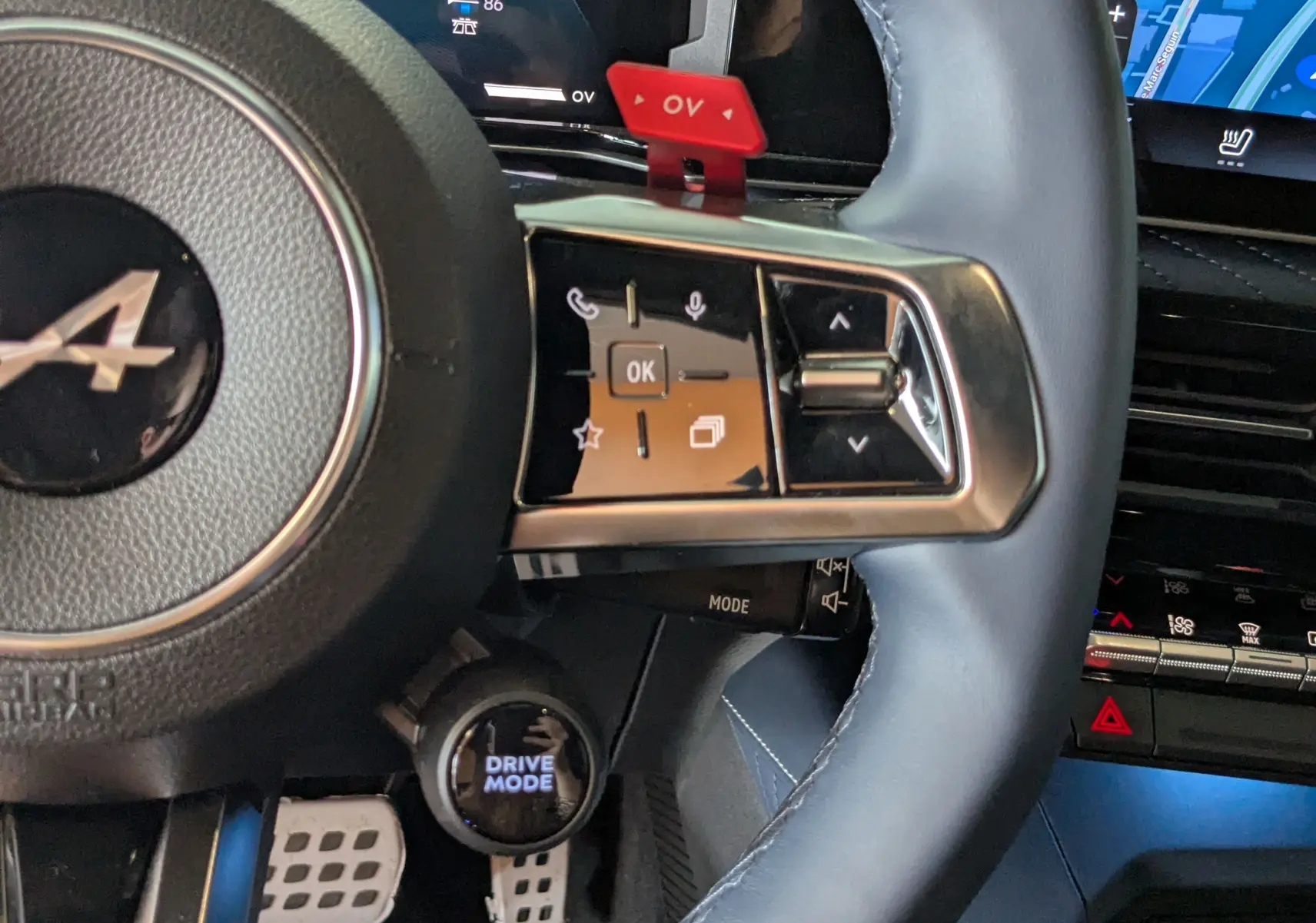 Gros plan sur le volant cuir bleu de l'Alpine A290 220CH GT PERFORMANCE avec commandes multifonctions et bouton Drive Mode.