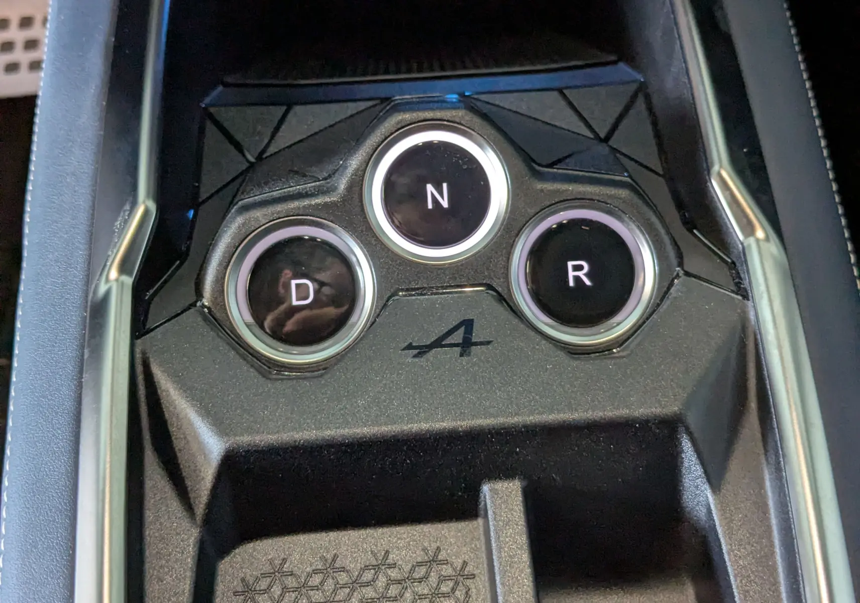Gros plan sur la console centrale noire de l'Alpine A290 avec boutons de boîte auto D, N, R et logo A.