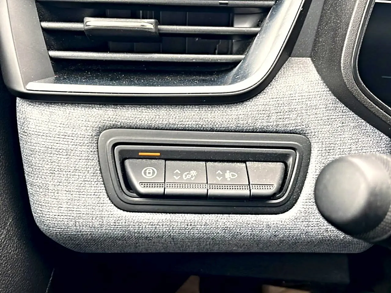 Détail des commandes d’éclairage et verrouillage sur tableau de bord gris texturé d’une Renault Clio V blanche.