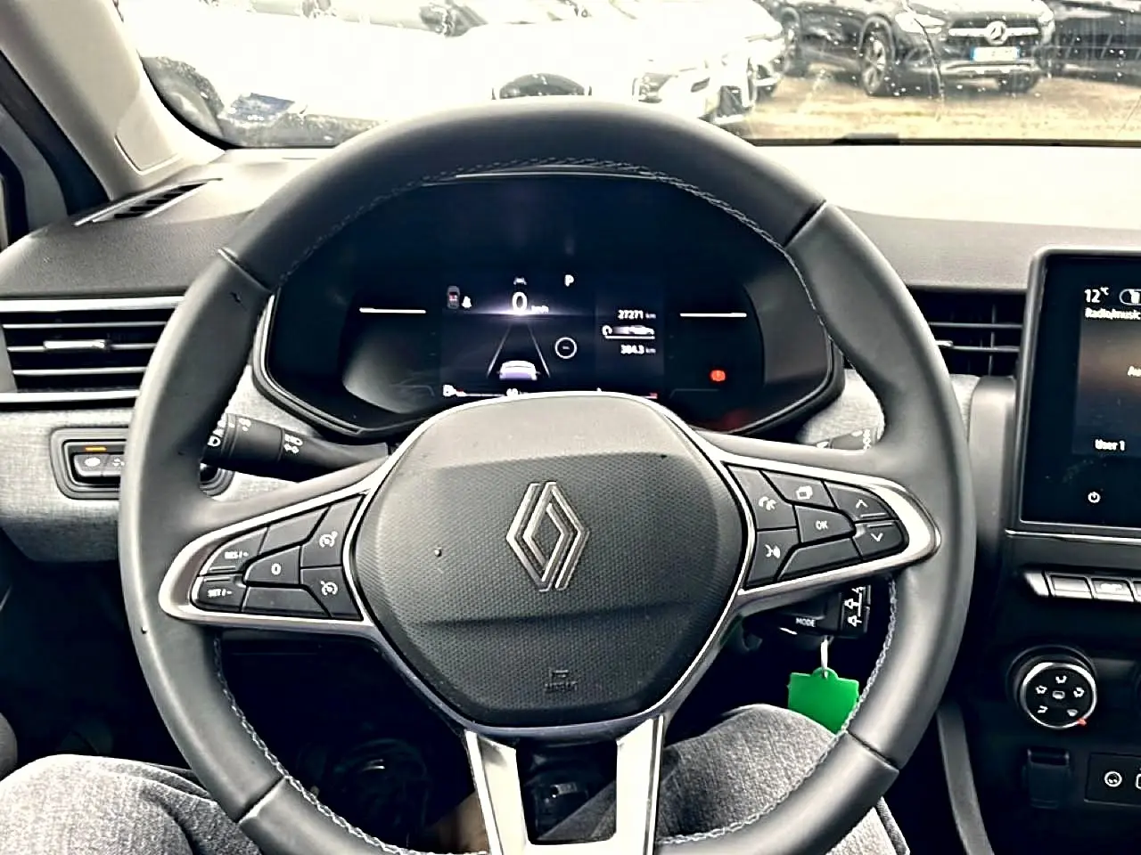Vue frontale du volant multifonction noir de la Renault Clio V avec tableau de bord numérique et écran tactile central.