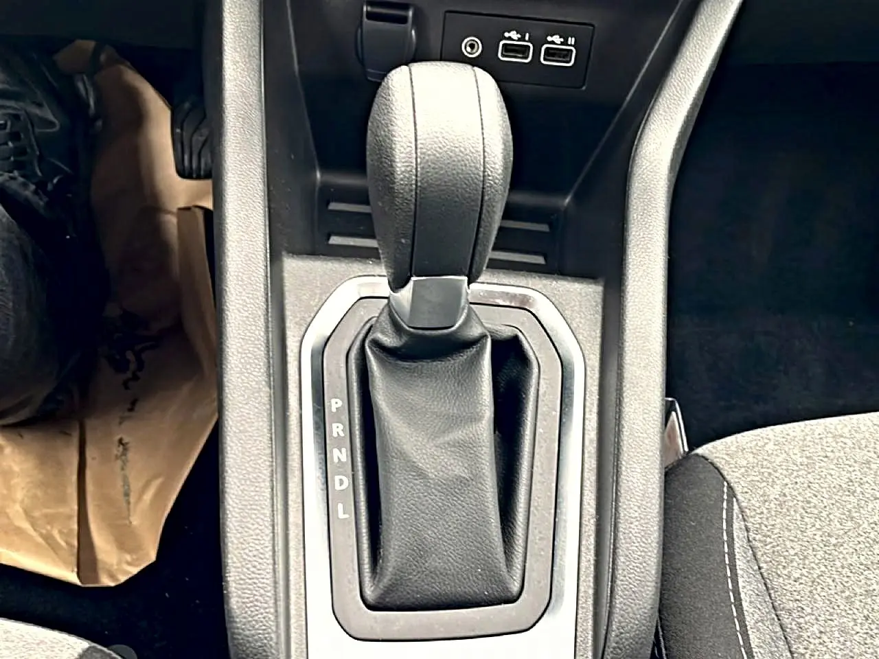 Le levier de boîte automatique noir de la Renault Clio V, vue rapprochée de la console centrale avec ports USB visibles.