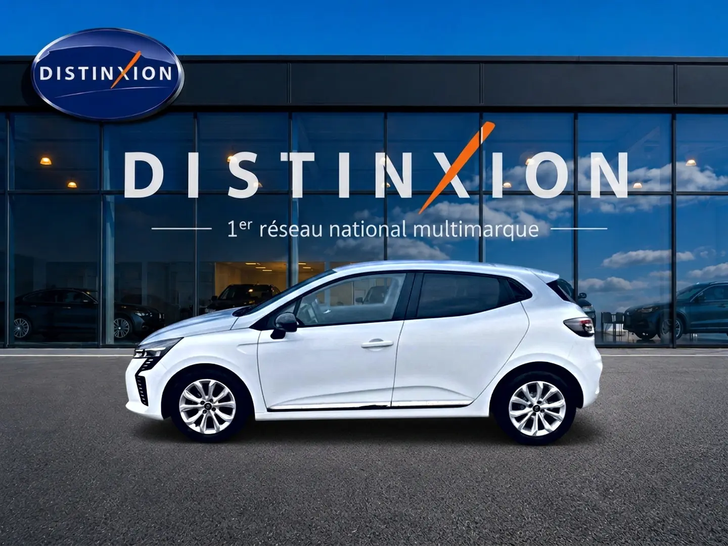 Renault Clio V blanche vue de profil côté gauche, avec jantes alliage et vitres teintées, devant une vitrine Distinxion.