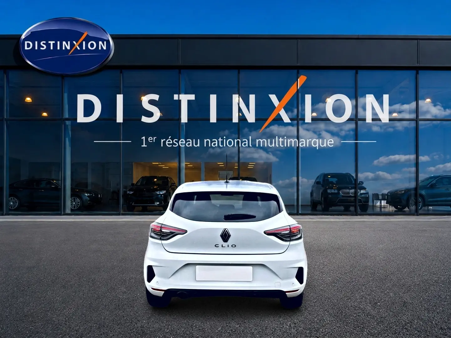 Vue arrière d'une Renault Clio V blanche 2025 garée devant une vitrine avec logo Distinxion.