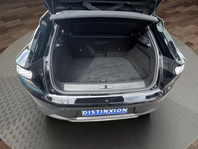 Coffre ouvert vu de l'arrière d'une DS4 E-TENSE 225 Cross Trocadero noire, montrant un espace de chargement spacieux.