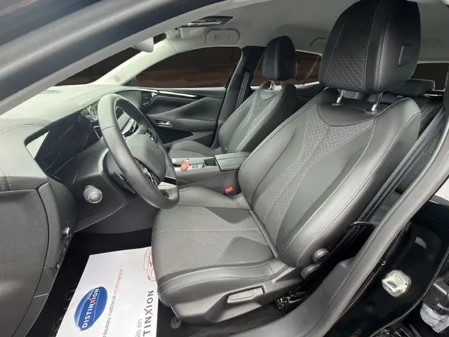 Vue intérieure côté conducteur de la DS4 E-TENSE 225 Cross Trocadero noire, sièges cuir noirs avec surpiqûres contrastées.