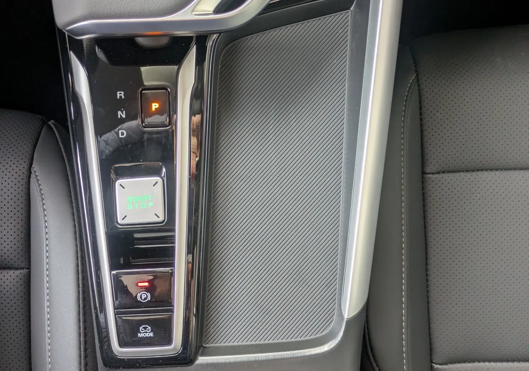 Vue plongeante sur la console centrale noire du MG ZS 1.5L Hybrid+ 2026 avec boîte auto et bouton start/stop éclairé.