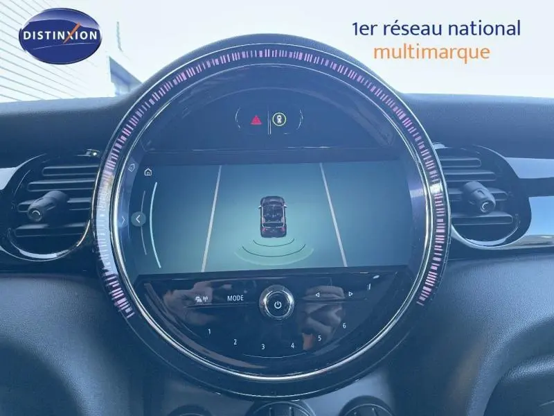 Affichage central rond du tableau de bord de la MINI Cabriolet Midnight Black II, montrant l'aide au stationnement active.