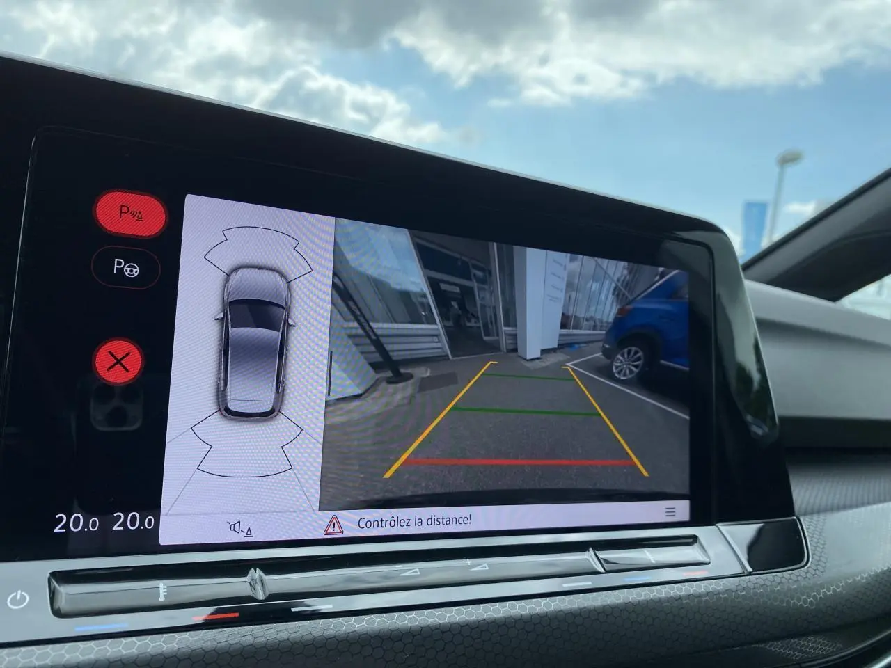 Affichage de la caméra de recul et des capteurs de stationnement sur l'écran tactile intérieur de la Volkswagen Golf noire.