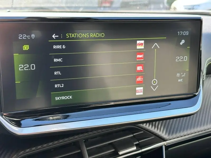 Écran tactile central du Peugeot 2008 Gris Artense 2022 affichant les stations radio et la climatisation à 22°C