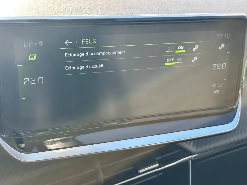 Écran tactile du tableau de bord du Peugeot 2008 affichant les réglages des feux d’éclairage à 22°C