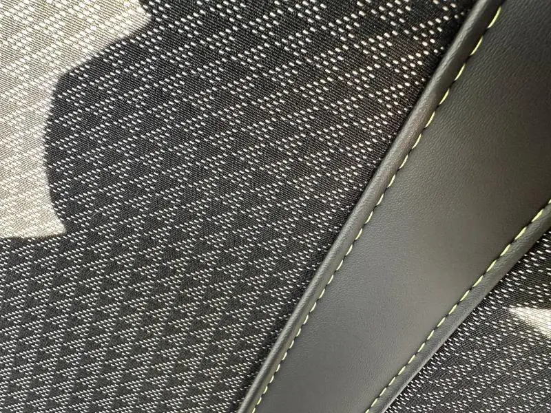 Gros plan sur le tissu gris à motif géométrique et surpiqûres contrastantes du siège avant du Peugeot 2008 GT 2022.