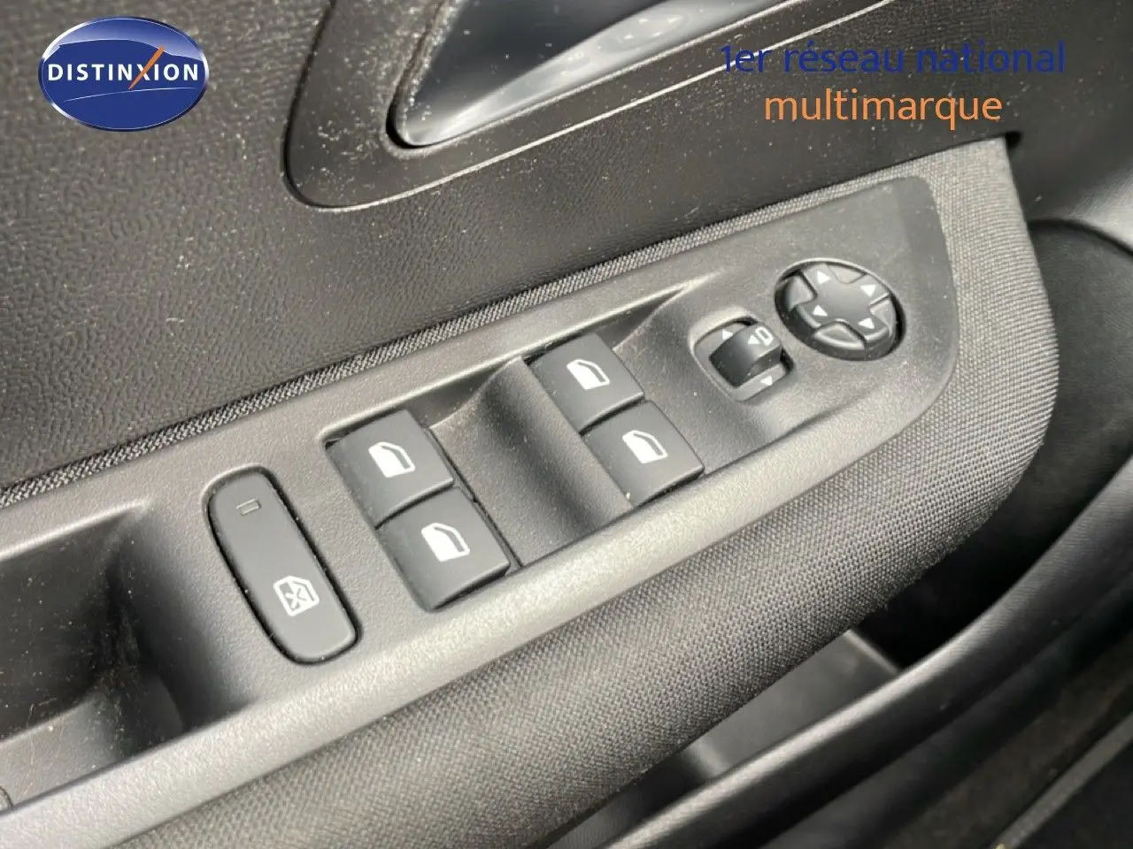 Gros plan sur les commandes de lève-vitres et rétroviseurs côté conducteur d'une Peugeot 208 1.5 BlueHDi rouge Elixir.