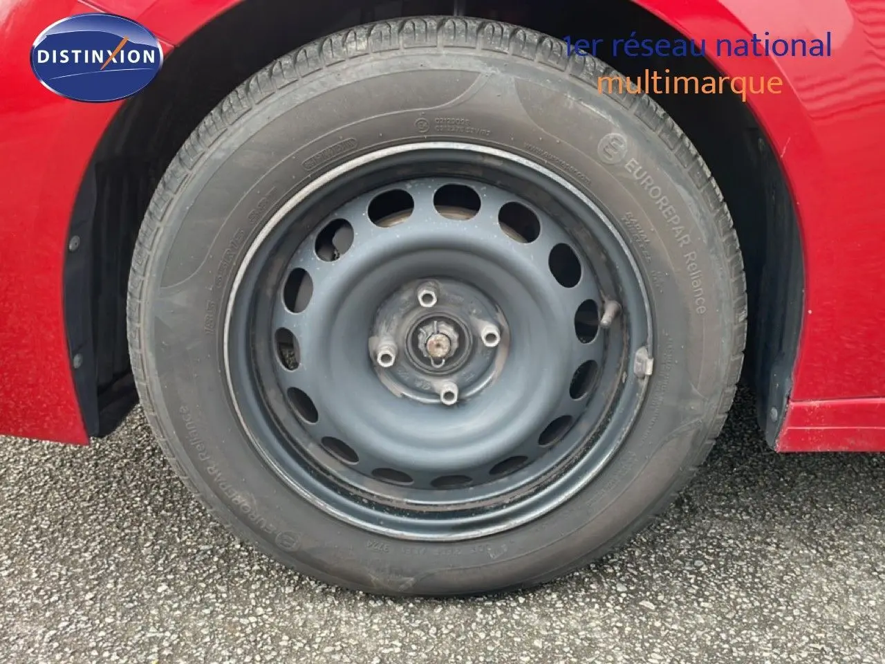 Gros plan sur la roue avant droite en jante acier d'une Peugeot 208 rouge Elixir Metal, version diesel 2022.