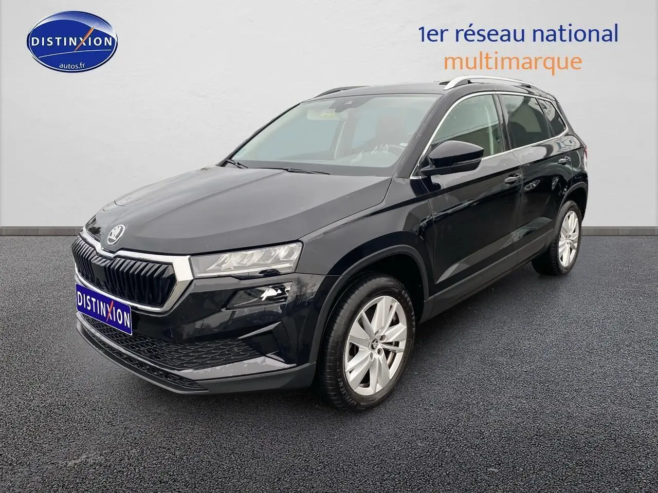 SUV SKODA KAROQ noir en 3/4 avant droit avec jantes alu et barres de toit visibles sur fond neutre.