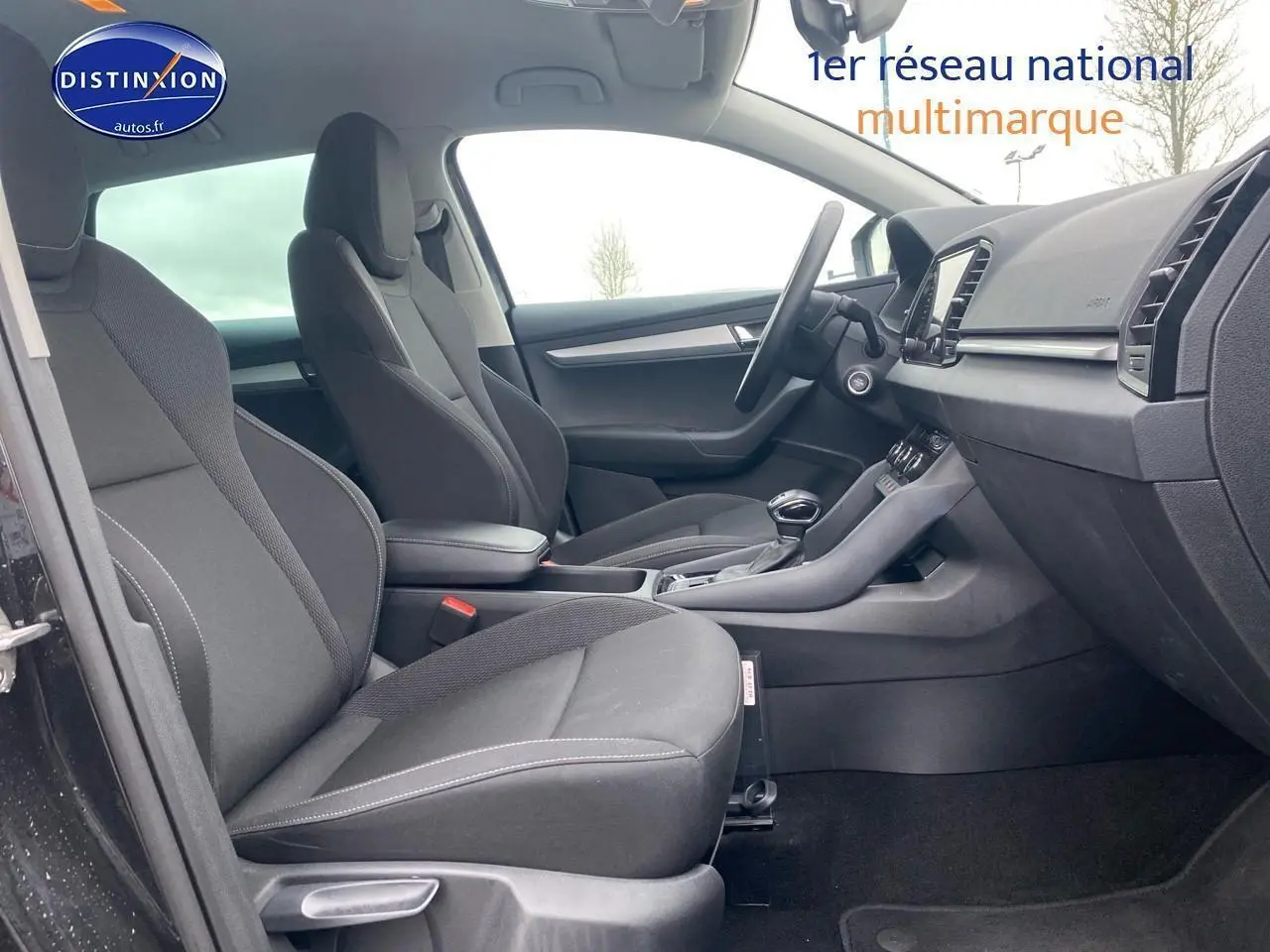 Vue intérieure côté gauche du Skoda Karoq noir 2025, mettant en valeur les sièges avant et la console centrale.