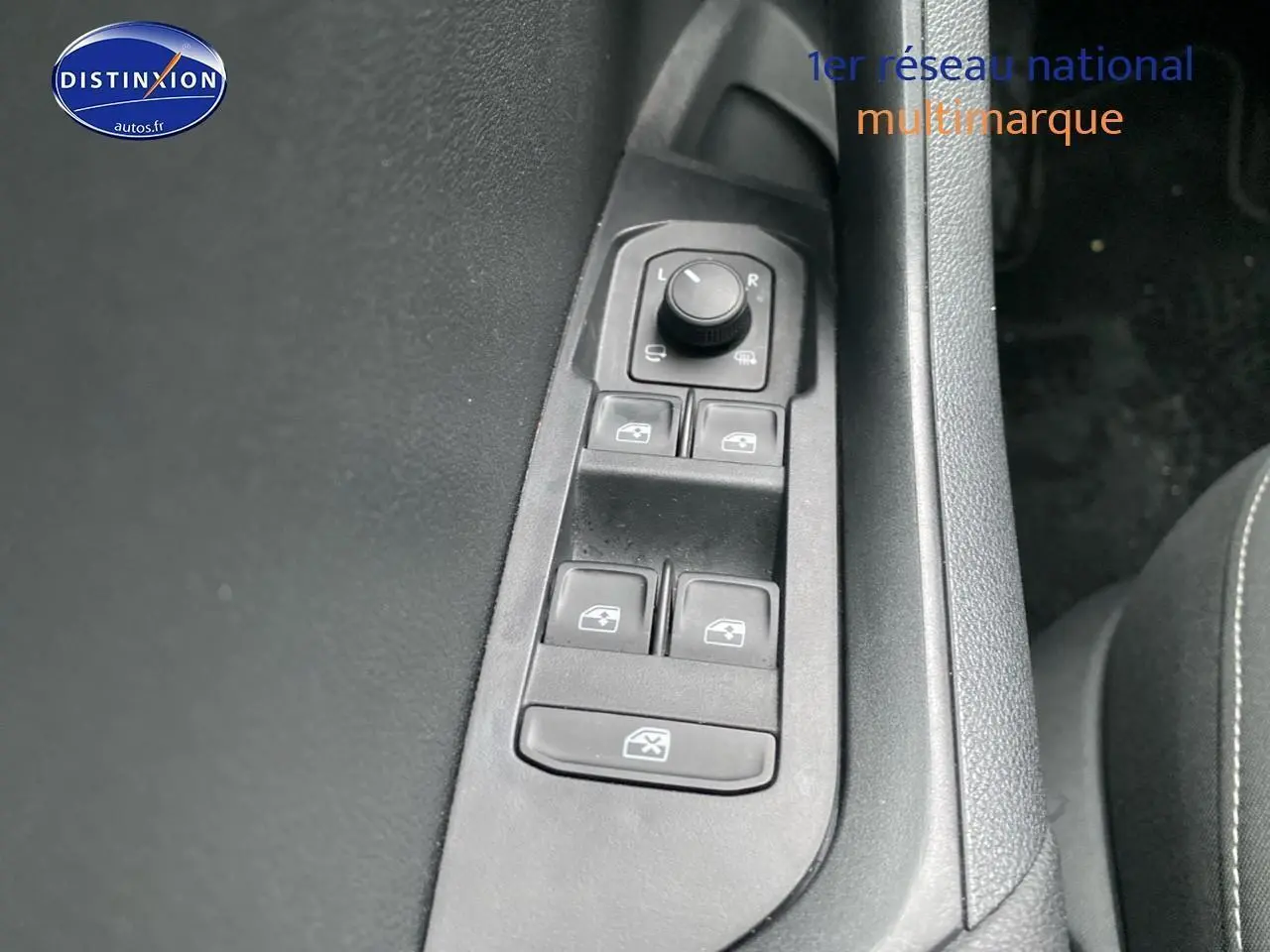 Gros plan sur les commandes des vitres et rétroviseurs côté conducteur d’un Skoda Karoq noir 2025.