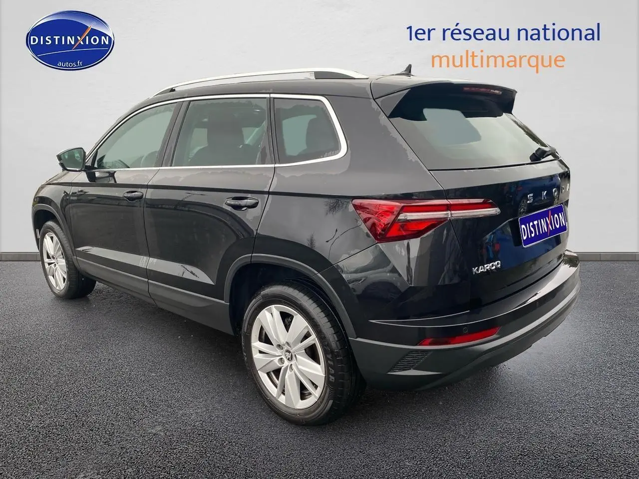 Vue 3/4 arrière droite d'un Skoda Karoq noir avec jantes alu et feux arrière LED distinctifs.