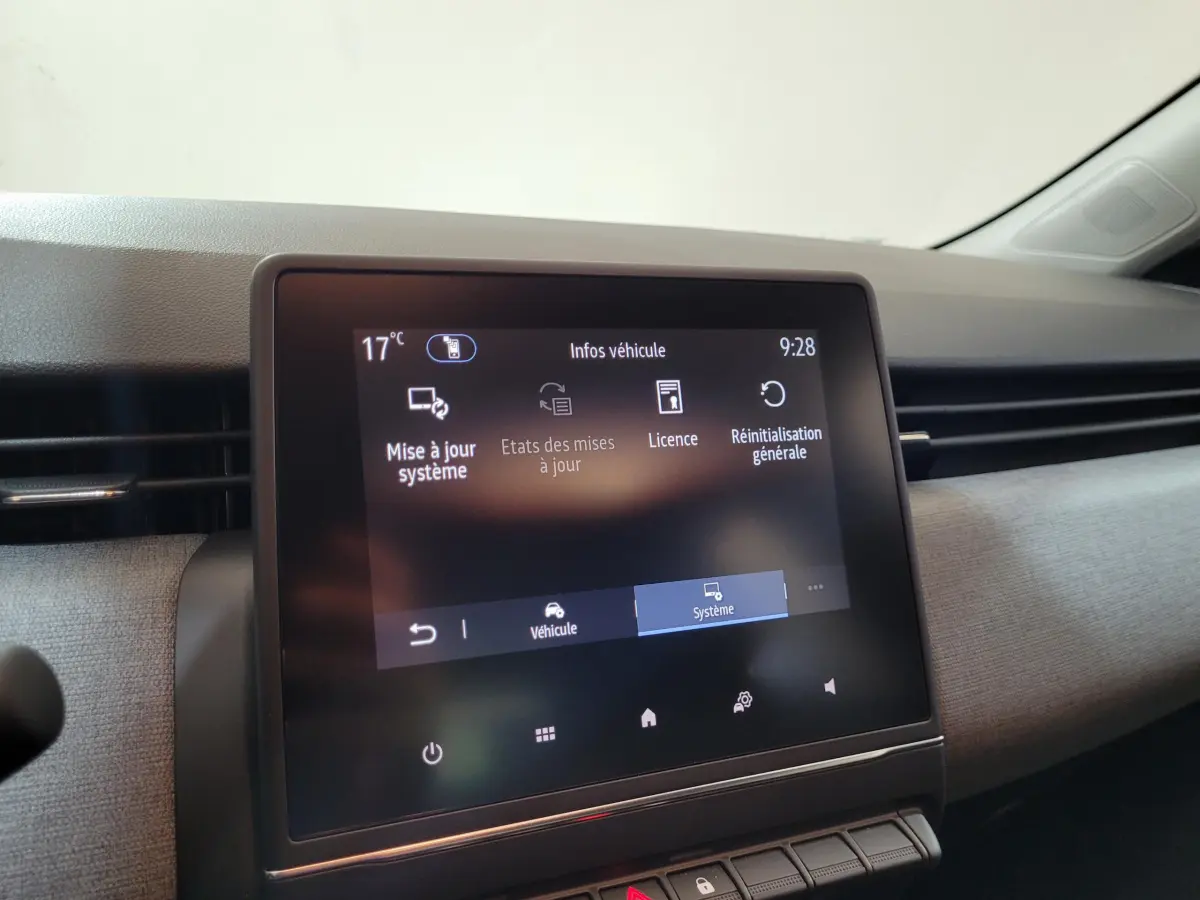 Écran tactile central affichant les options système du tableau de bord d’une Renault Clio gris foncé, vue intérieure.