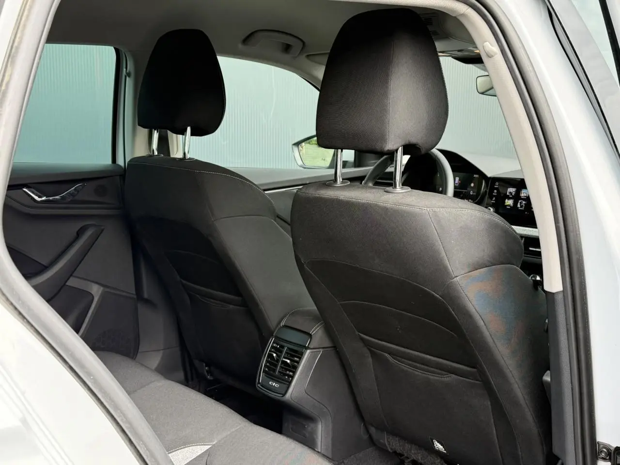 Vue arrière intérieure de la Skoda Scala blanc glacier, montrant les sièges noirs et la console centrale avec aérateurs.