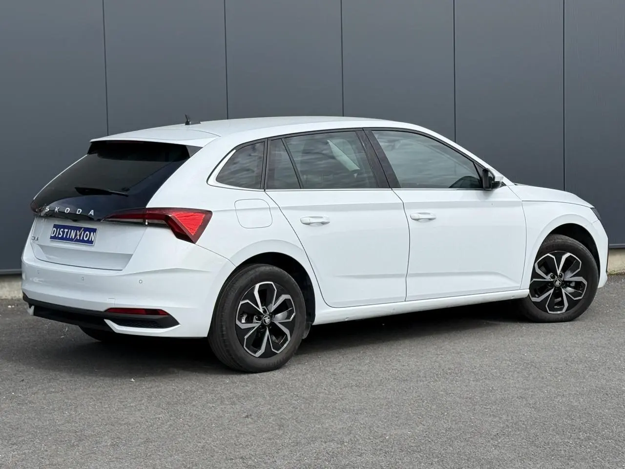 Vue 3/4 arrière droite d'une Skoda Scala blanc glacier avec vitres surteintées et jantes alliage 16 pouces.