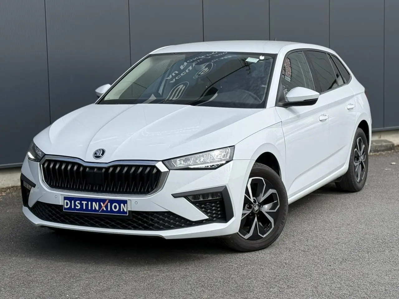 Vue 3/4 avant droite d'une Skoda Scala TSI 116 DSG7 blanc glacier avec jantes alliage et vitres surteintées.