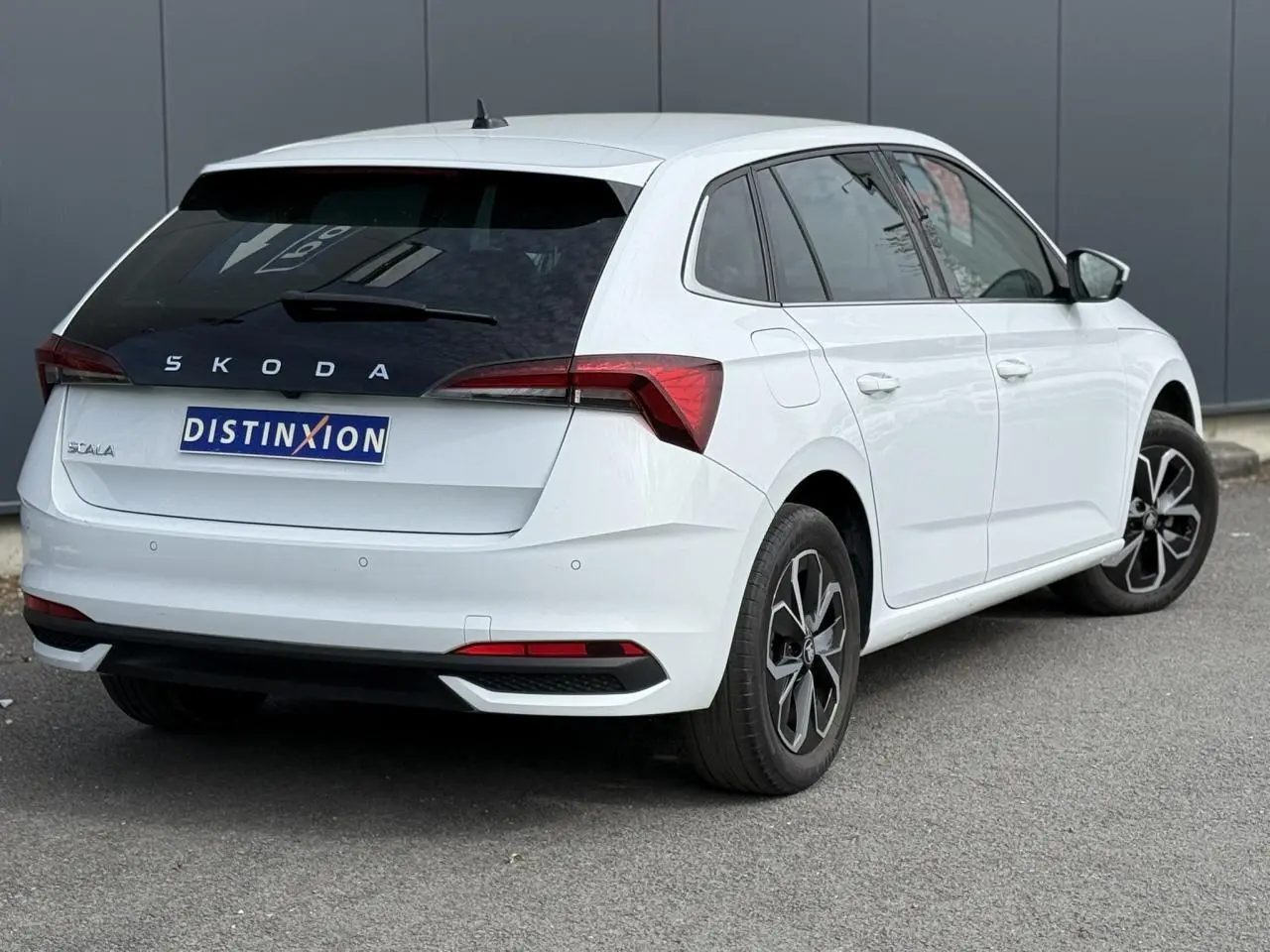 Vue 3/4 arrière droite d'une Skoda Scala blanc glacier avec vitres surteintées et jantes alliage 16 pouces.