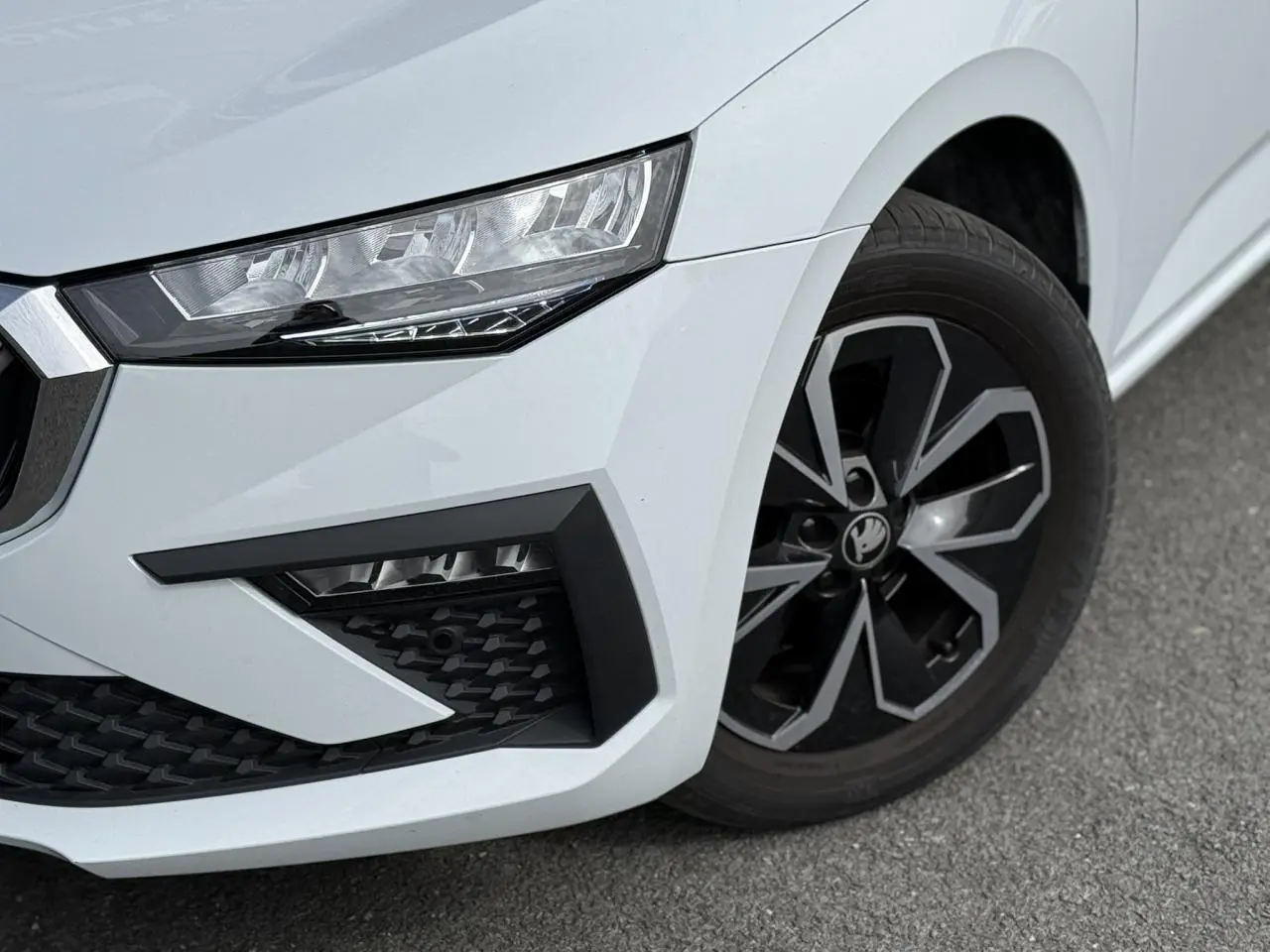 Gros plan sur l'avant droit blanc glacier d'une Skoda Scala TSI 116 DSG7 avec jante alliage et phares LED.