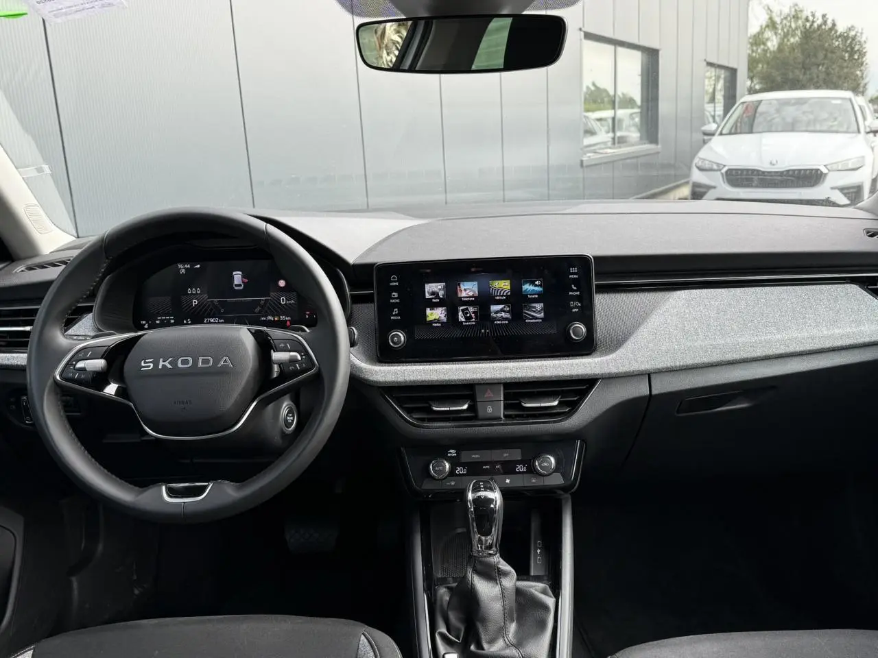 Vue intérieure frontale du tableau de bord de la Skoda Scala blanc Glacier, avec écran tactile et volant multifonction.