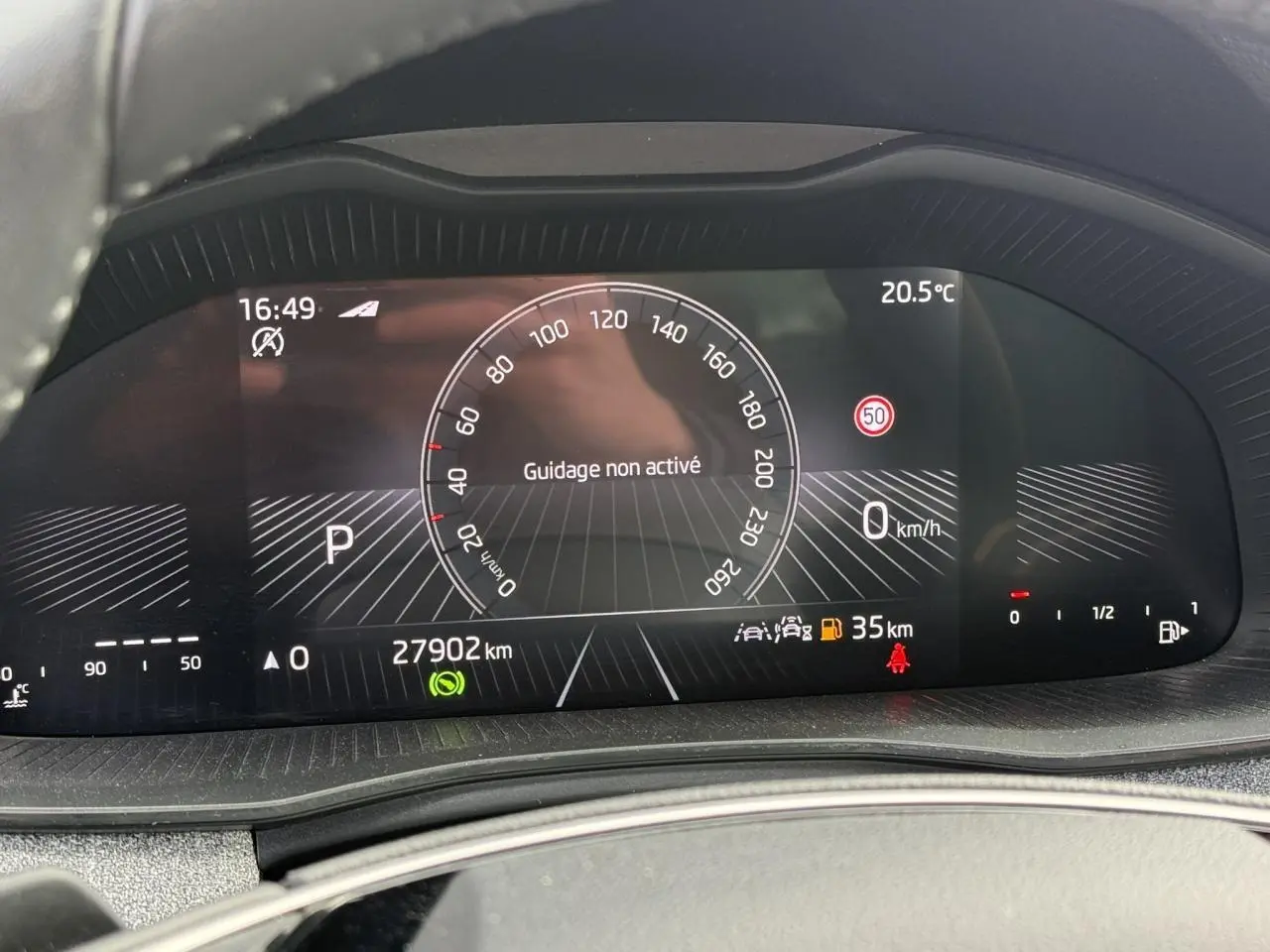 Tableau de bord numérique de la Skoda Scala blanc glacier, affichant la vitesse à 0 km/h et 27 902 km au compteur.