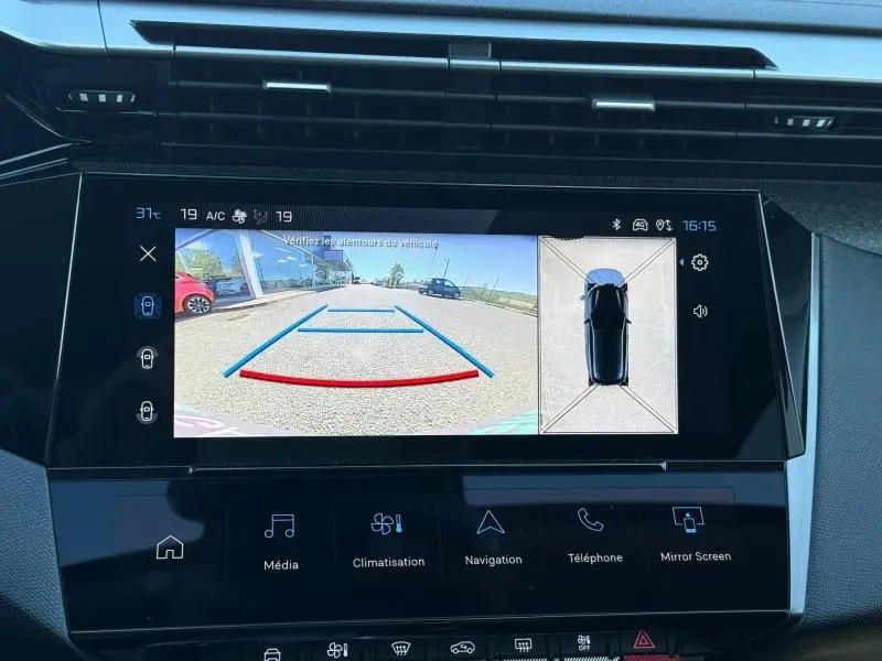 Écran central de la Peugeot 308 hybride 2025 montrant la caméra de recul avec vue arrière et top-down en gris.