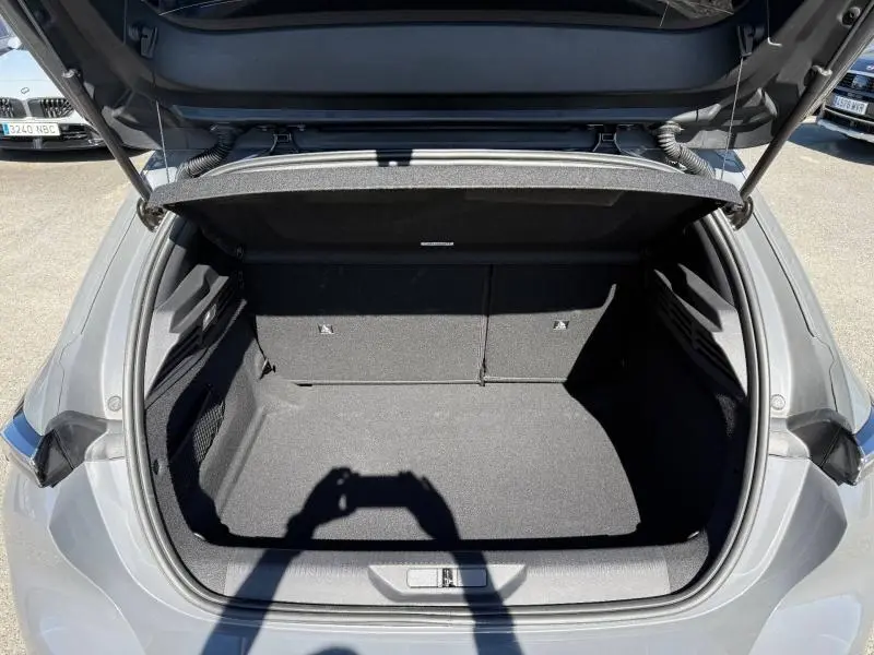 Coffre ouvert vu de l'arrière d'une Peugeot 308 gris 2025, montrant un espace de chargement propre et spacieux.