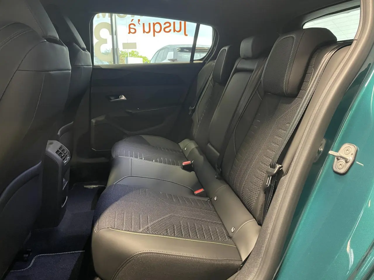 Vue latérale droite de la banquette arrière en tissu noir avec surpiqûres vert Adamite sur Peugeot 308 Bleu Lagoa.