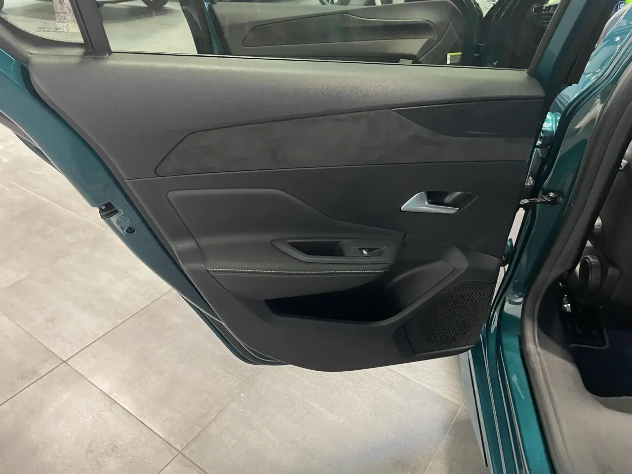 Vue intérieure de la porte arrière gauche bleu métallisé de la Peugeot 308 GT avec surpiqûres vert Adamite.