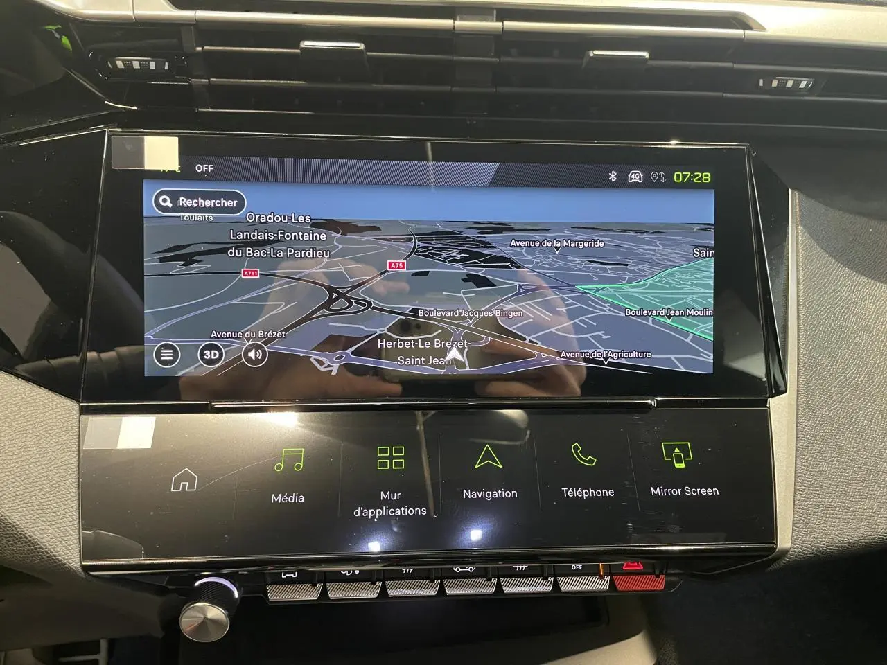 Vue rapprochée de la console centrale noire avec écran tactile affichant la navigation sur Peugeot 308 bleu.