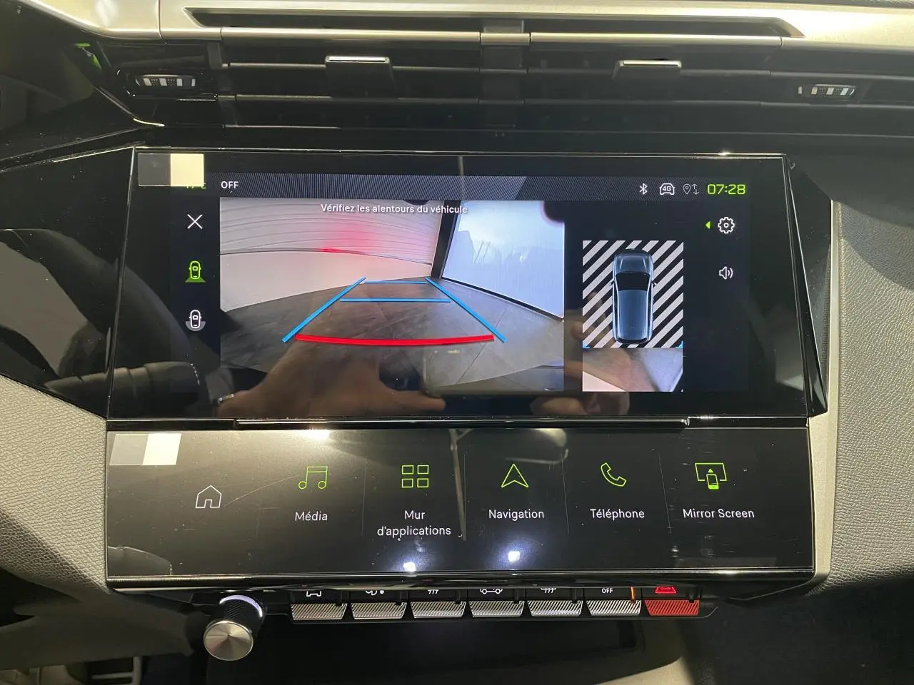Écran tactile central affichant la caméra de recul et les options multimédia dans une Peugeot 308 GT bleue.