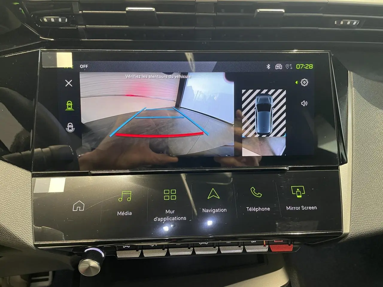 Écran tactile central de la Peugeot 308 bleu montrant la caméra de recul et l'interface multimédia.