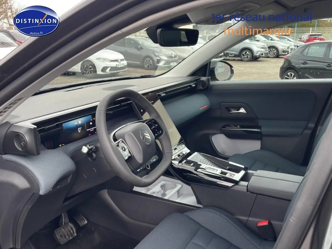Vue intérieure côté conducteur du Citroën C5 Aircross hybride 2026, avec tableau de bord moderne et sièges gris foncé.