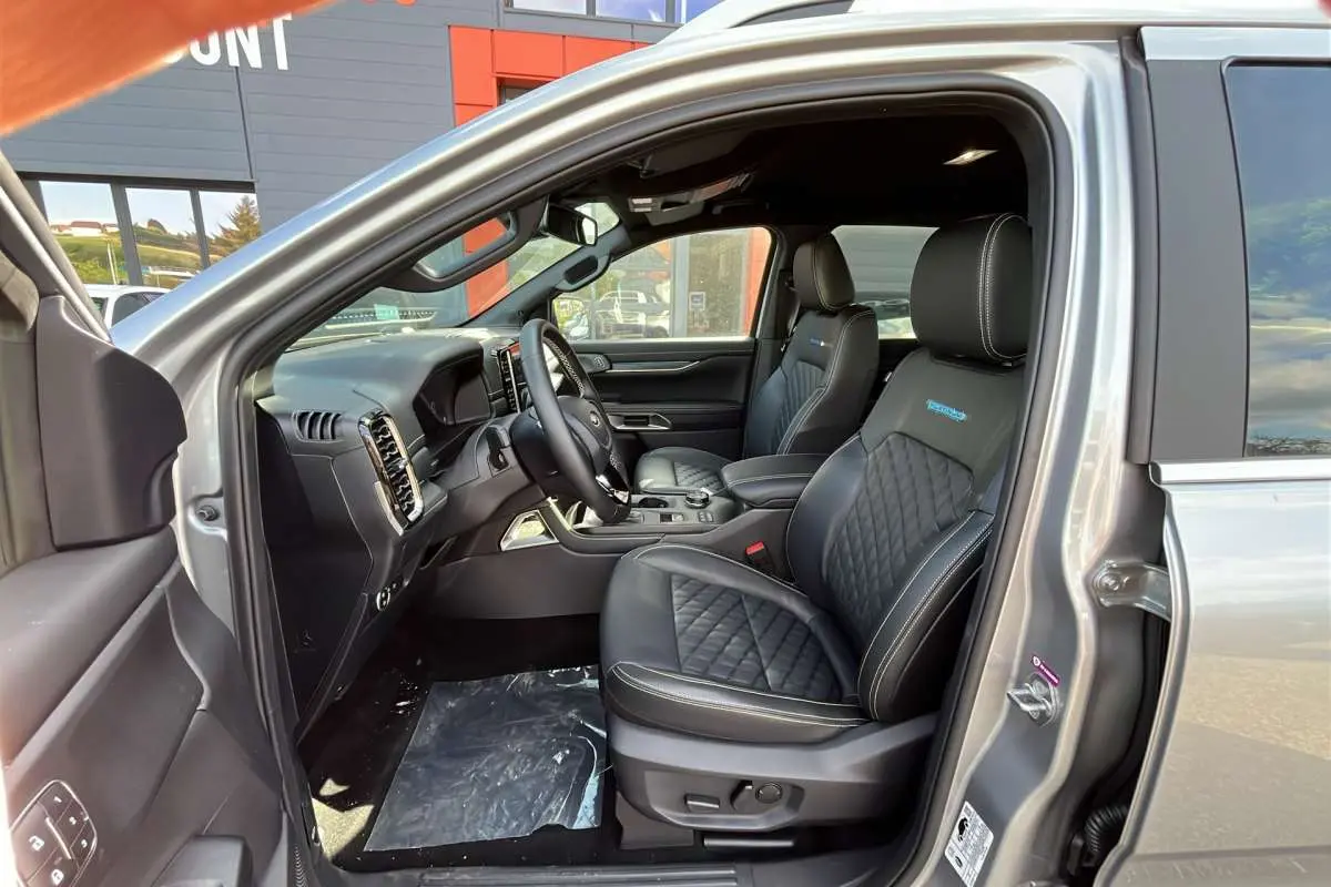 Vue intérieure côté conducteur du Ford Ranger 2026 gris iconic, sièges cuir noirs matelassés avec logo Platinum Rideau.