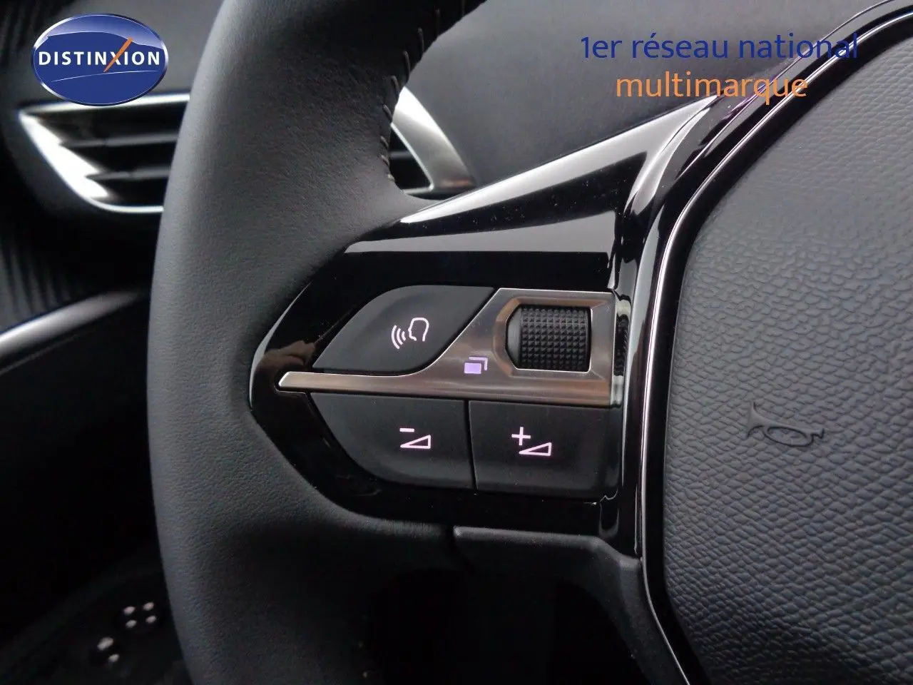 Gros plan sur les commandes du volant à gauche du Peugeot 3008 gris Artense 2023, avec boutons de volume et reconnaissance vocale.