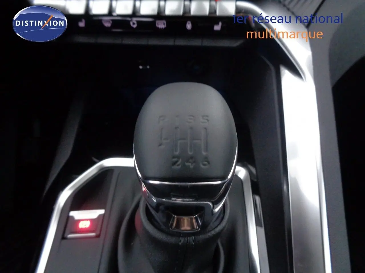 Gros plan sur le levier de vitesses manuel noir du Peugeot 3008 gris Artense, avec éclairage rouge du frein à main électronique.