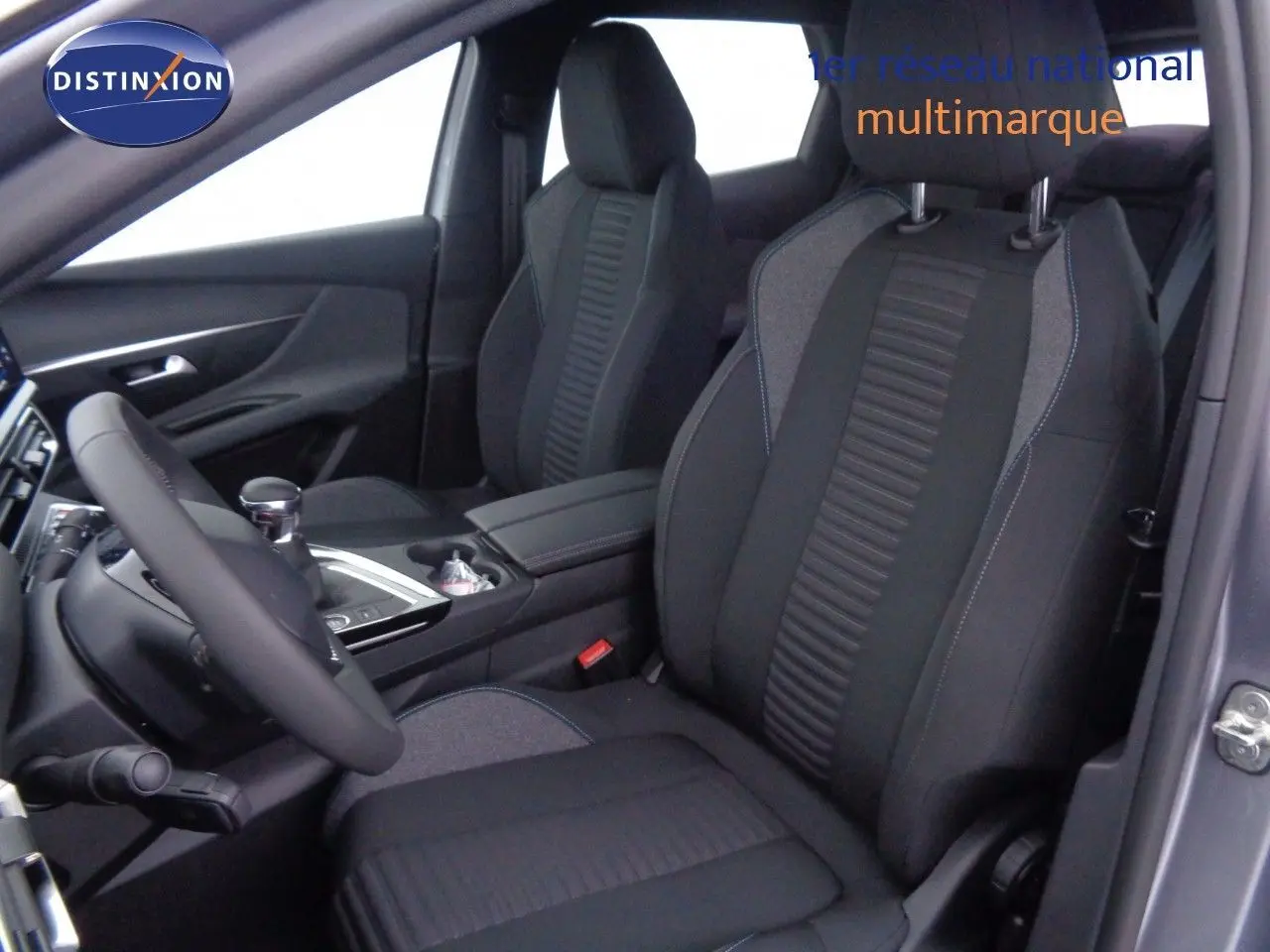 Vue intérieure côté conducteur du Peugeot 3008 2023 gris Artense Metal, sièges tissu gris et noir avec surpiqûres bleues.